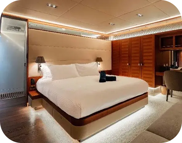 Eclipse cabin with a wide made-up double bed, bedside lamps, wood wardrobes and a desk chair