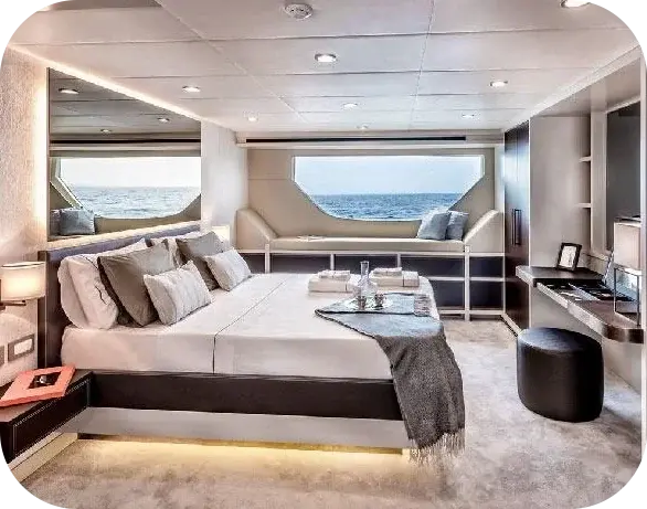 Out of Office cabin with a double bed, a cushioned window seat under a wide hull window and a dressing table with a stool