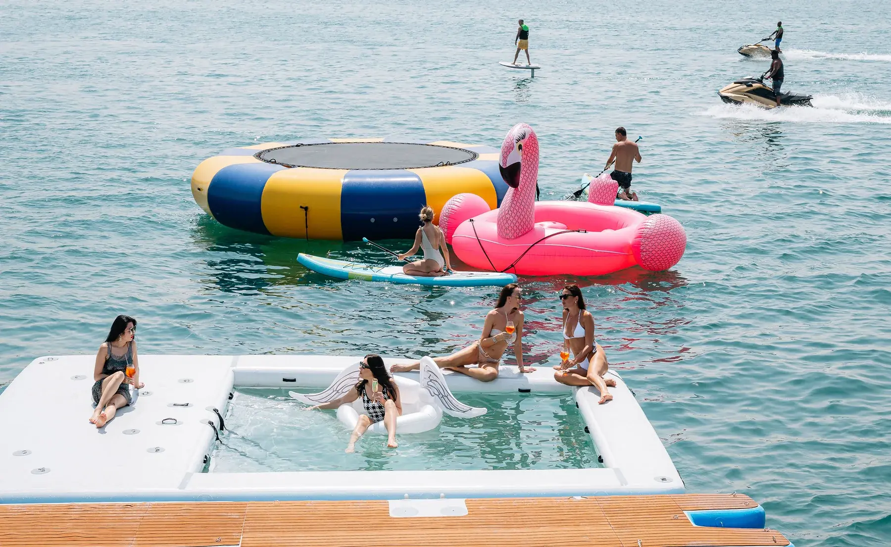 Floating sea pool, trampoline and jet skis beside AK Royalty