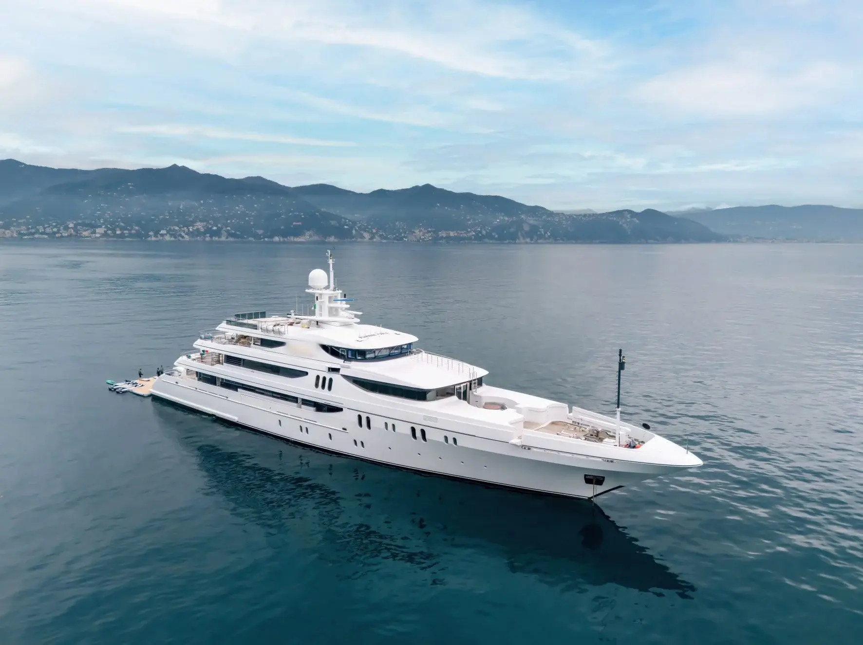 Blue Ocean, a white 66 m superyacht with four decks, at anchor in calm water